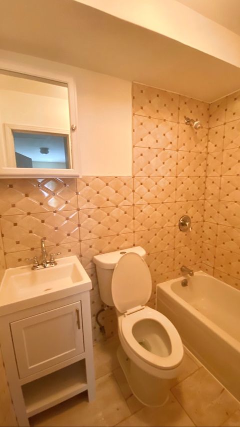 Bathroom remodel — natural-stone vanity with backlit mirror