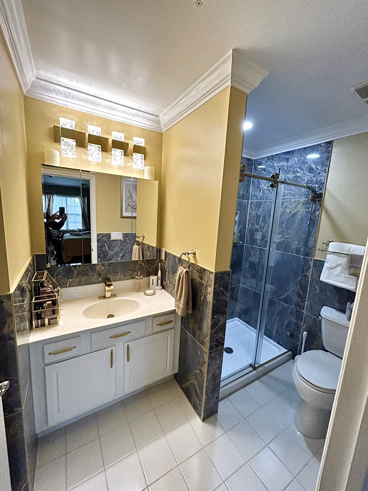 Bathroom remodel — yellow accent walls with dark-tile shower